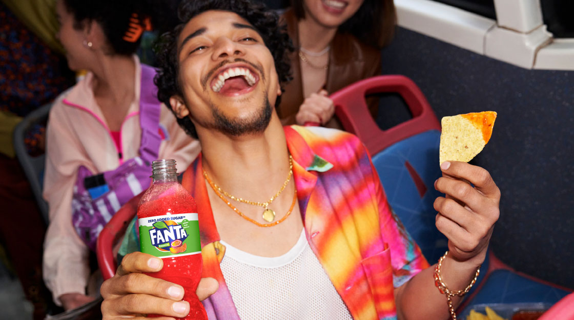 Man drinking fanta and eating nachos