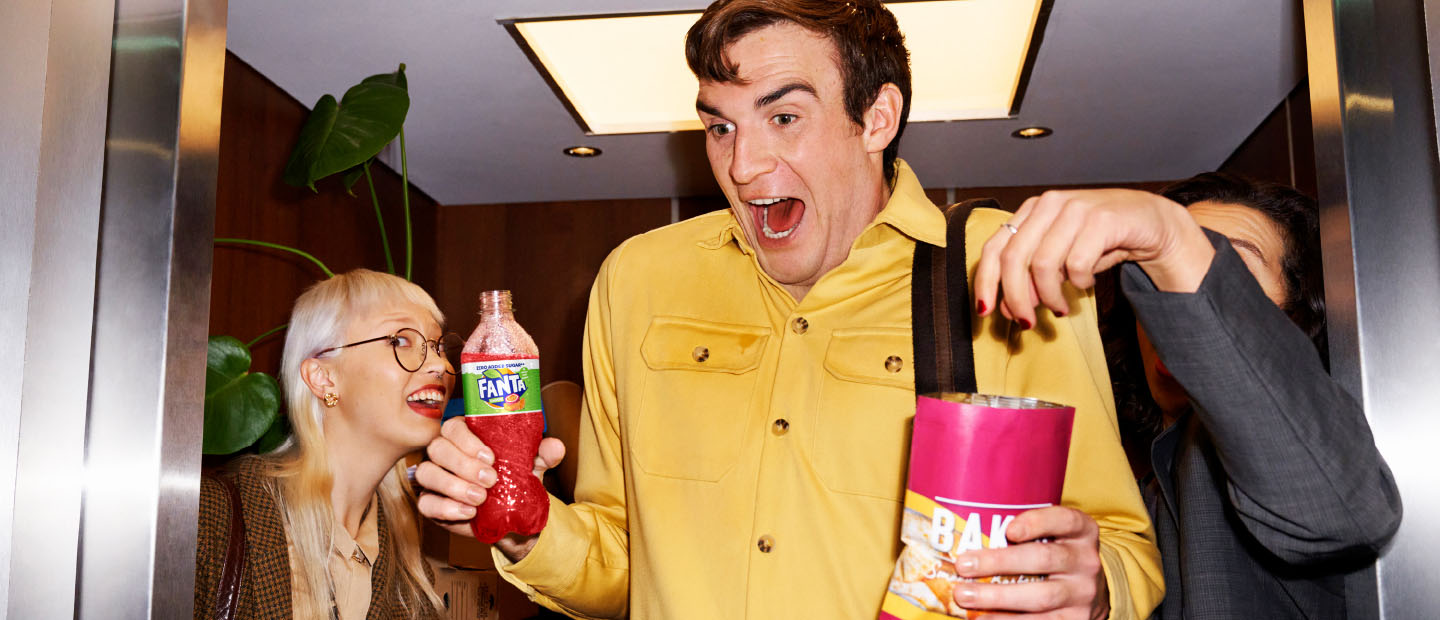 Man drinking fanta and eating snacks