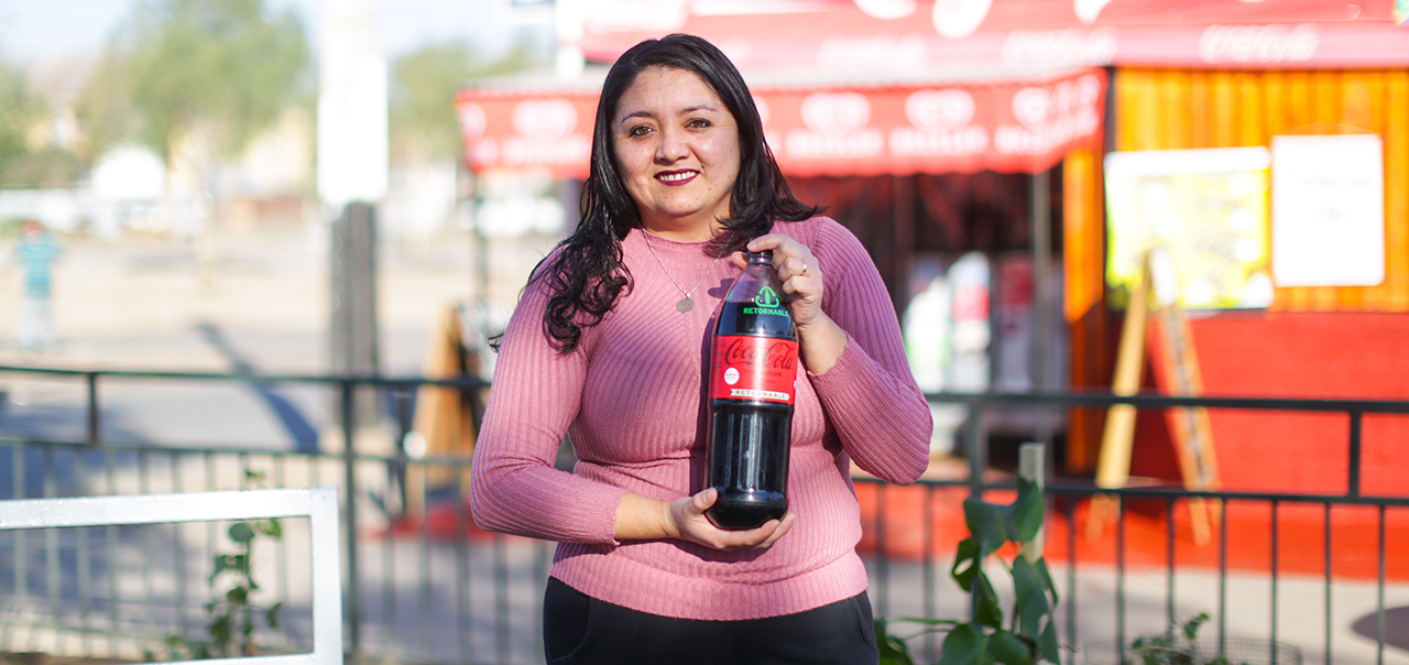 Mujer sosteniendo botella plástica de Coca-Cola Zero, tamaño familiar.