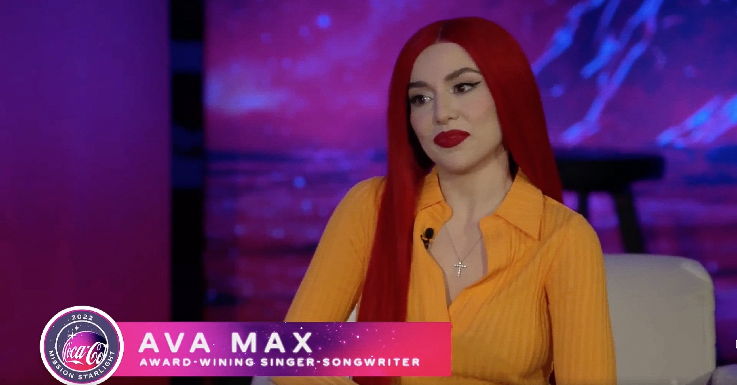Foto de Ava Max, con pelo rojo y camisa naranja.