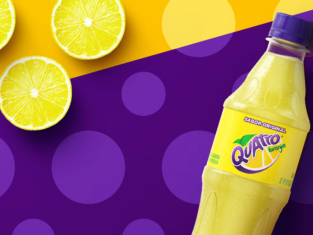 botella de bebida Quatro sabor Toronja sobre un fondo amarillo y violeta con lunares y limones