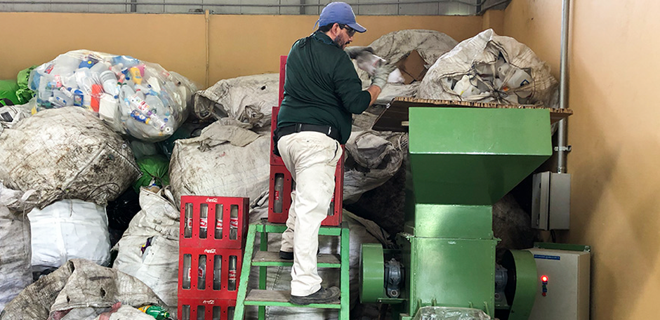 Hombre y bolsas en centro de acopio de residuos