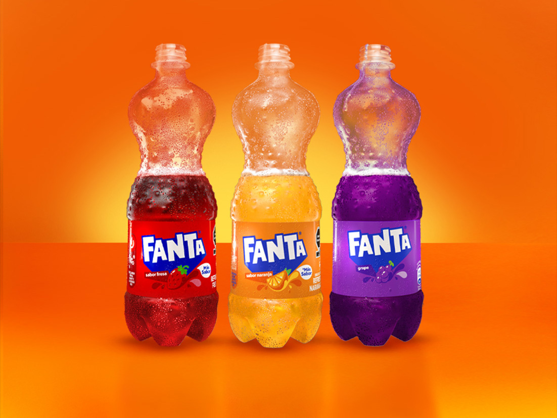 Tres botellas de Fanta de diferentes sabores - fresa, naranja y uva - destapadas con el refresco por la mitad, alineadas sobre fondo naranja brillante.