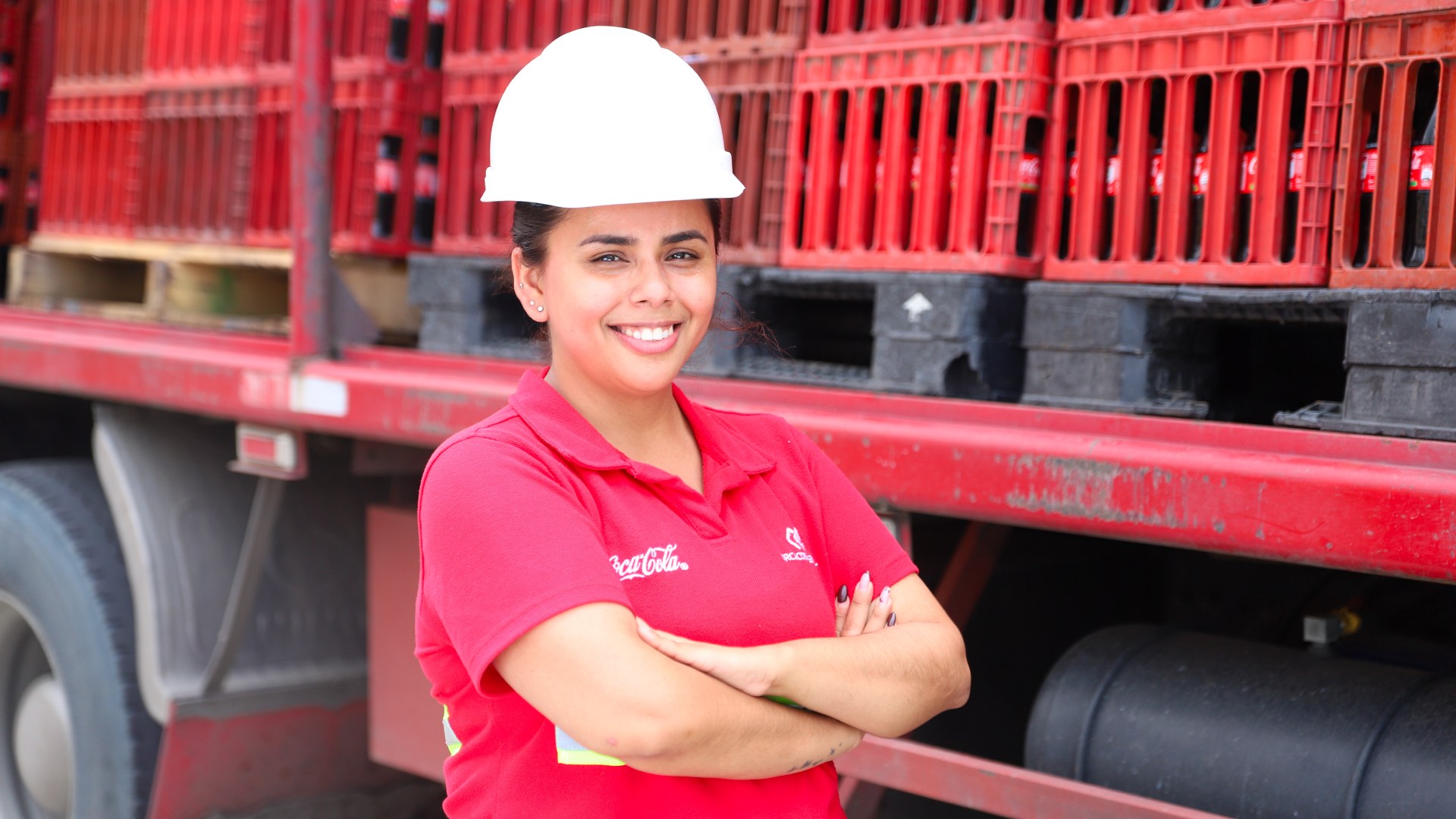 Trabajadora de Coca-Cola con una remera roja y un casco blanco