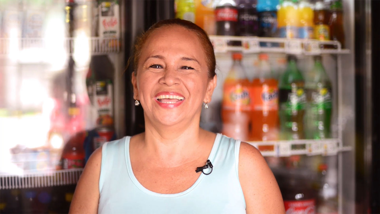 Mujer sonriendo con botellas de Coca-Cola de fondo