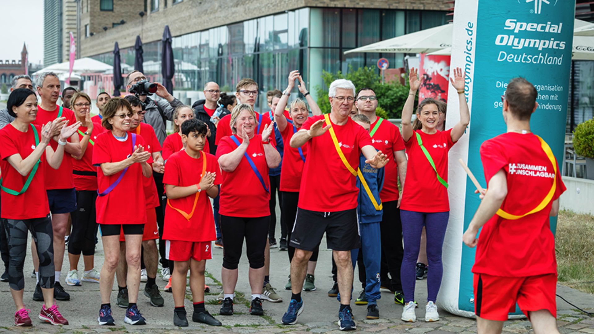 Coca-Cola Corporate Volunteers und Athleten und Athletinnen von Special Olympics feuern sich beim Staffellauf gegenseitig an. Coca-Cola Corporate Volunteers und Athleten und Athletinnen von Special Olympics feuern sich beim Staffellauf gegenseitig an.