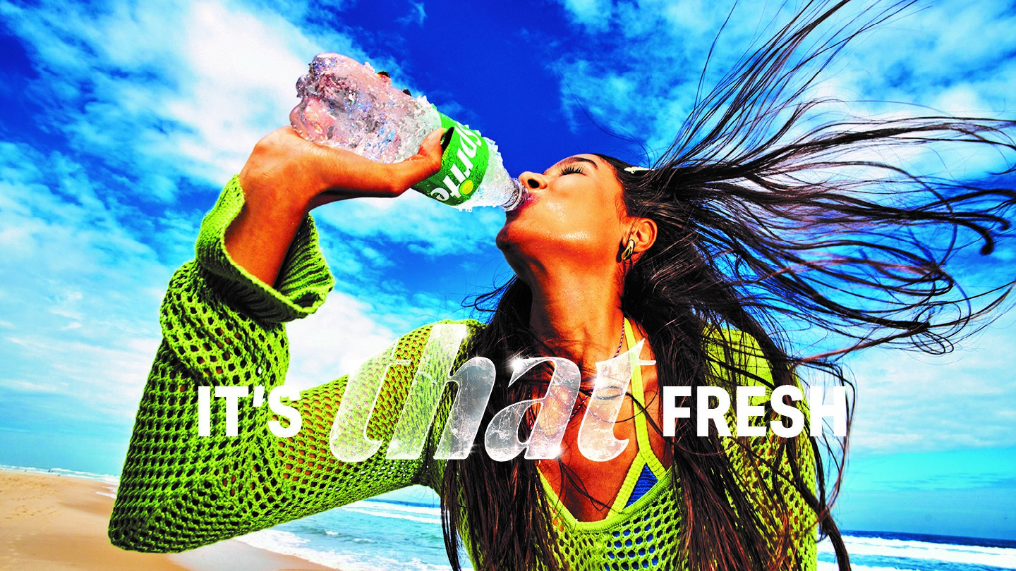 Eine Frau trinkt eine Flasche Sprite