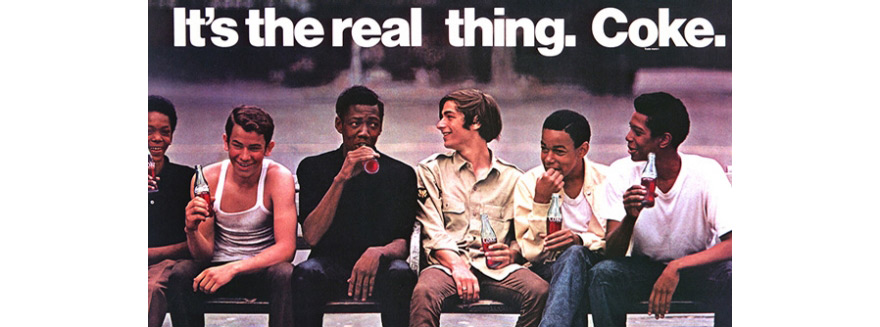Mehrere Männer sitzen in einer Reihe und halten eine Flasche Coca-Cola in der Hand. Darüber steht der Satz "It's the real thing. Coke".