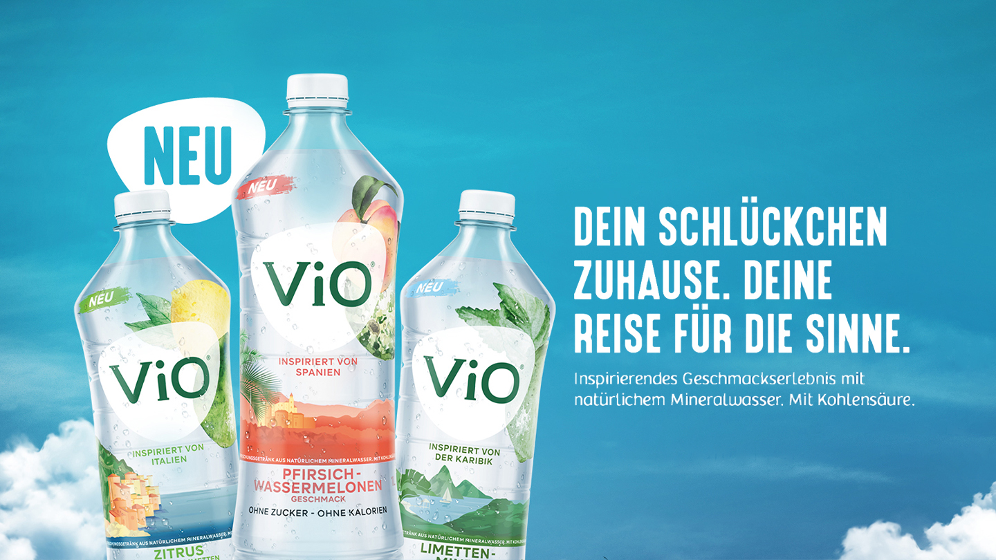 Drei verschiedene Flaschen ViO Mineralwasser, rechts davon der Text "Dein Schlückchen zuhause. Deine Reise für die Sinne. Inspirierendes Geschmackserlebnis mit natürlichem Mineralwasser. Mit Kohlensäure."