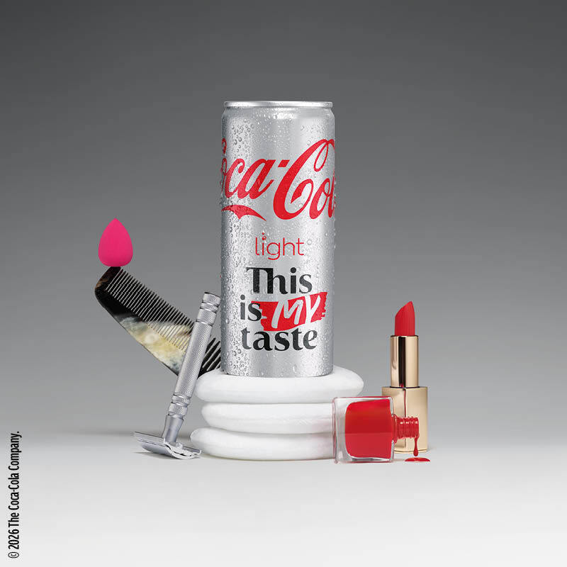 Eine Coca-Cola Light Dose, umgeben von Make-up und Kosmetikprodukten.