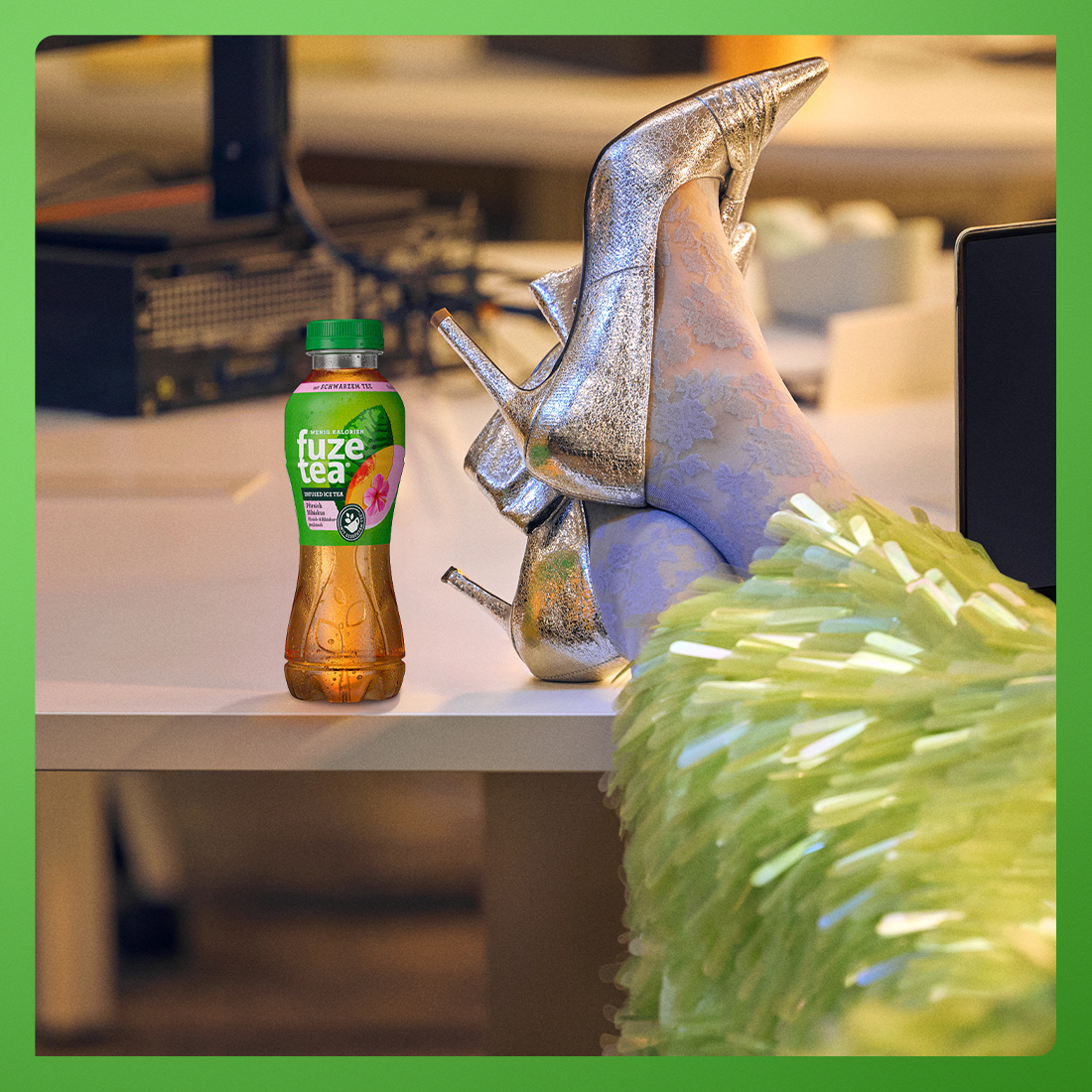 Hochhackige Füße neben einer Flasche Fuze-Tee aufstellen
