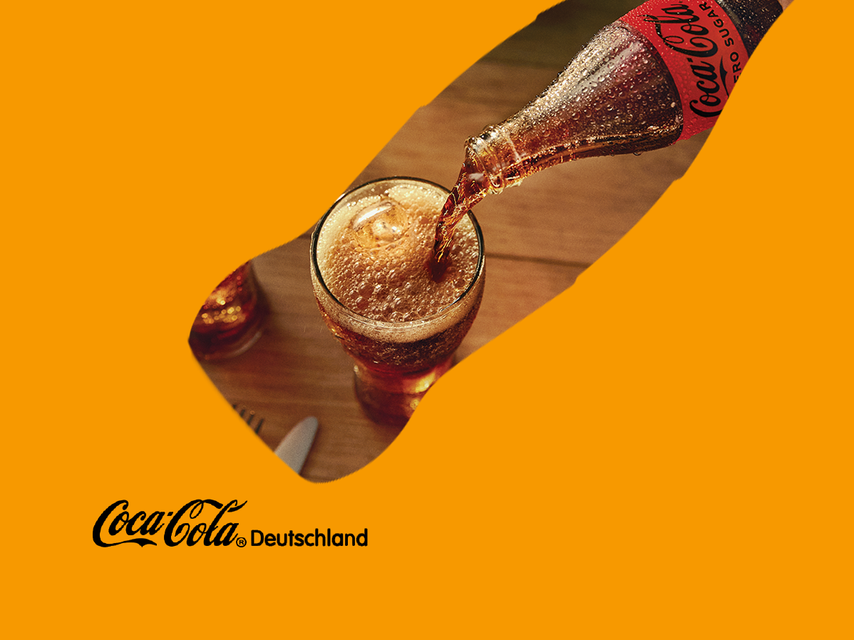 Eine Hand gießt Coca-Cola Zero Sugar aus einer gekühlten Glasflasche in ein Glas mit Eis. Im Vordergrund links steht das Logo von Coca-Cola Deutschland auf orangem Hintergrund.