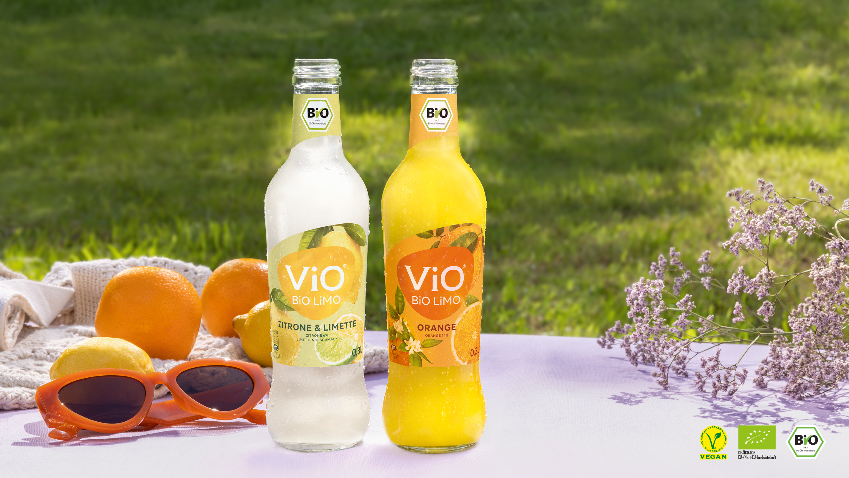 Vier Flaschen ViO BiO-LiMO in verschiedenen Geschmacksvarianten. Rechts unten sind drei Bio-Zertifizierungslogos zu sehen.
