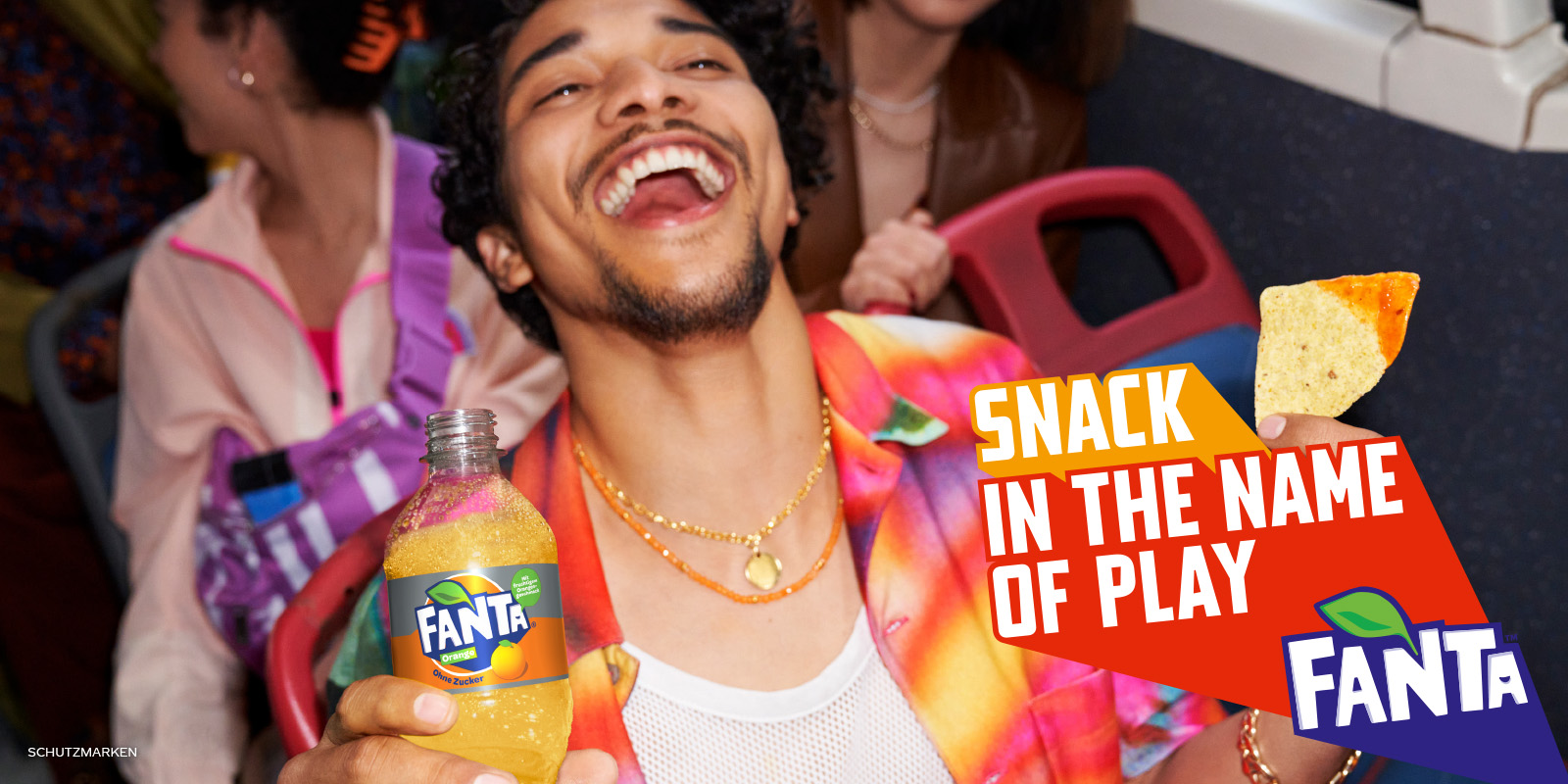 Man drinking fanta and eating nachos