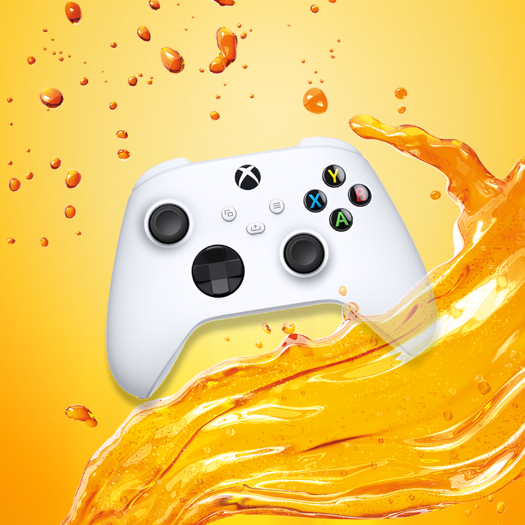 A white handheld gaming console and a white Xbox controller are displayed against a bright orange background, alongside a navy Fanta-branded cap and a pair of Fanta-branded socks arranged as a promo-style bundle.