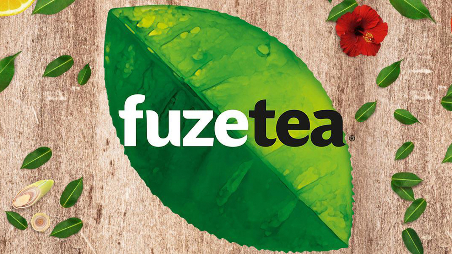 Grafik med Fuze Tea-logo og teblade og frugtstykker på træ-baggrund