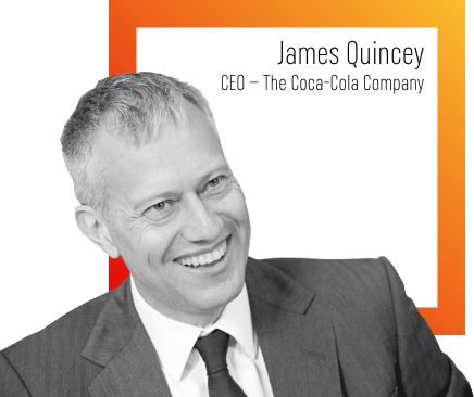 Sort/hvid-billede af smilende James Quincey, CEO hos The Coca-Cola Company, på gråt baggrundsbillede med orange firkant