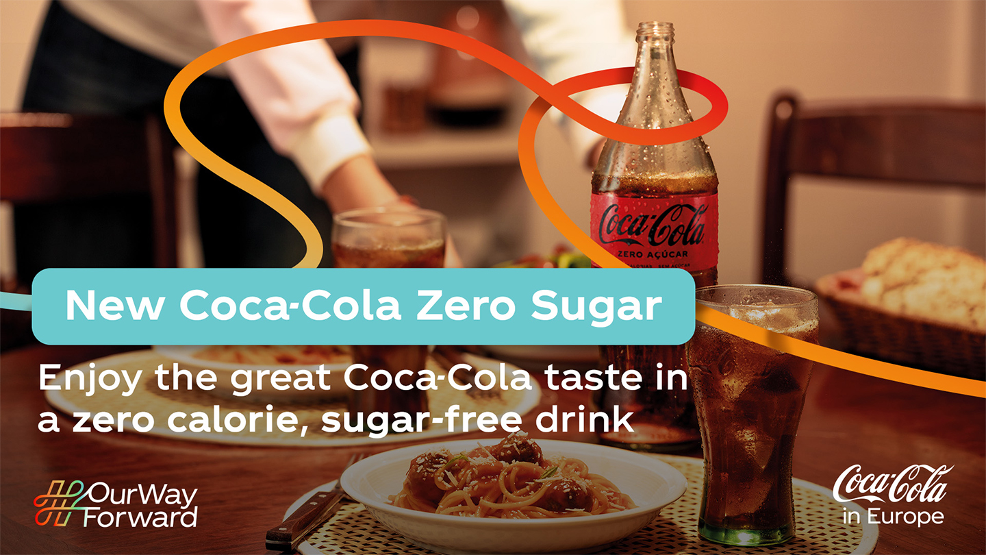 Reklametekst om sukkerfri Coca-Cola Zero samt baggrundsbillede med Coca-Cola Zero og pastaret på spisebord