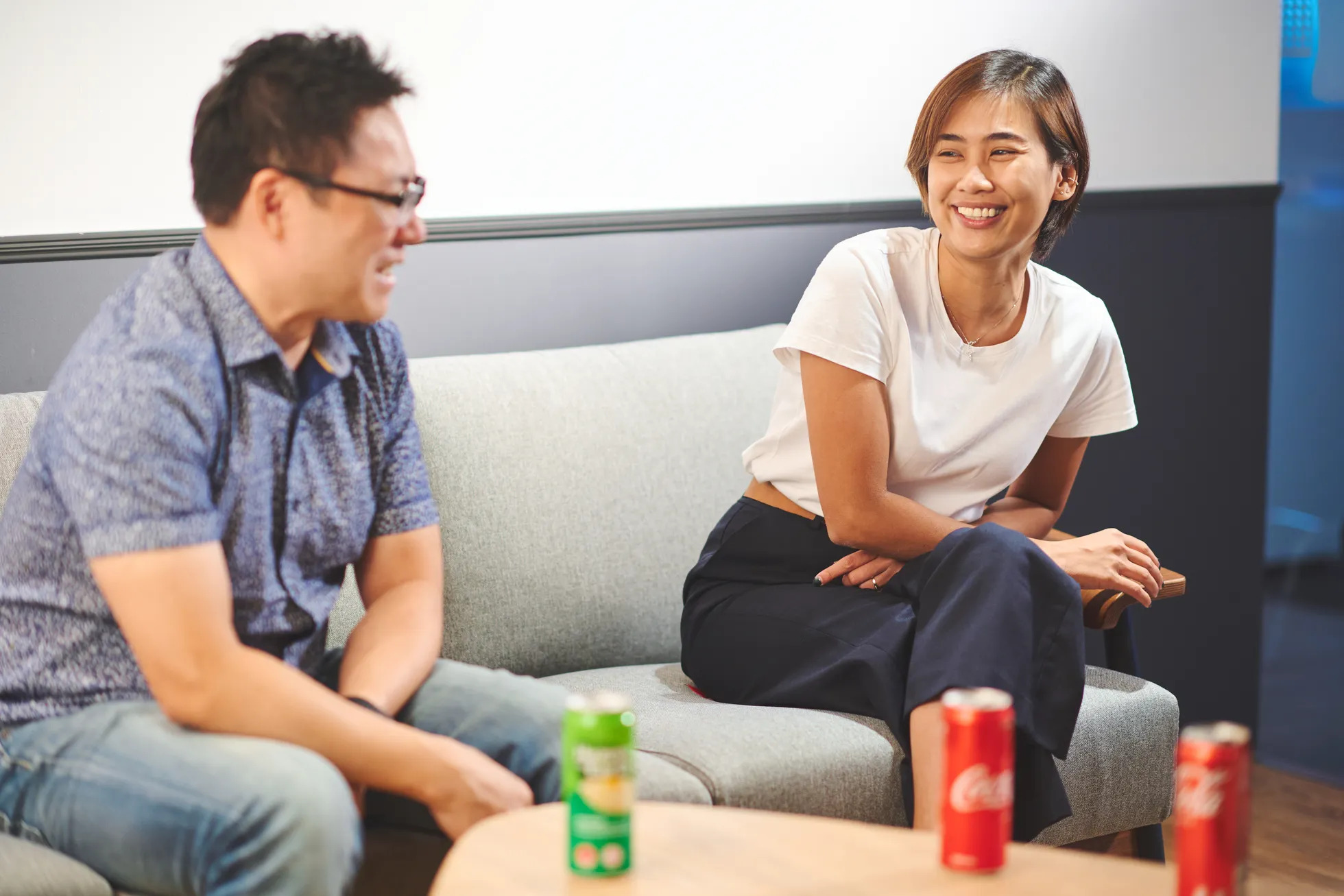 Un homme et une femme profitent de leur conversation en dégustant des boissons Coca-Cola et Sprite