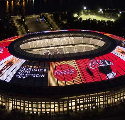 Le logo de Coca-Cola est illuminé au sommet du toit du stade du terrain de jeu