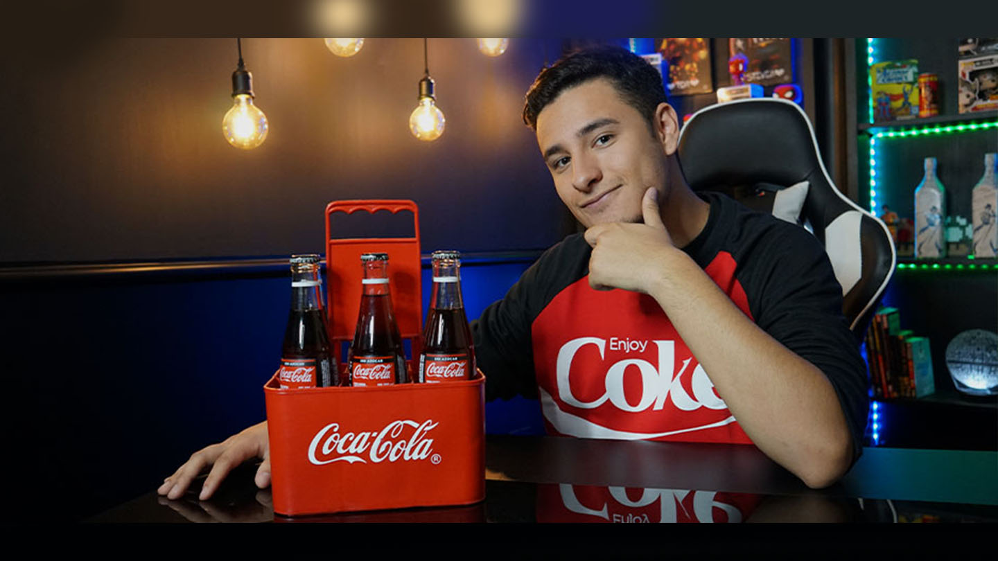 Juan Sid sentado junto a un pack de botellas de Coca-Cola