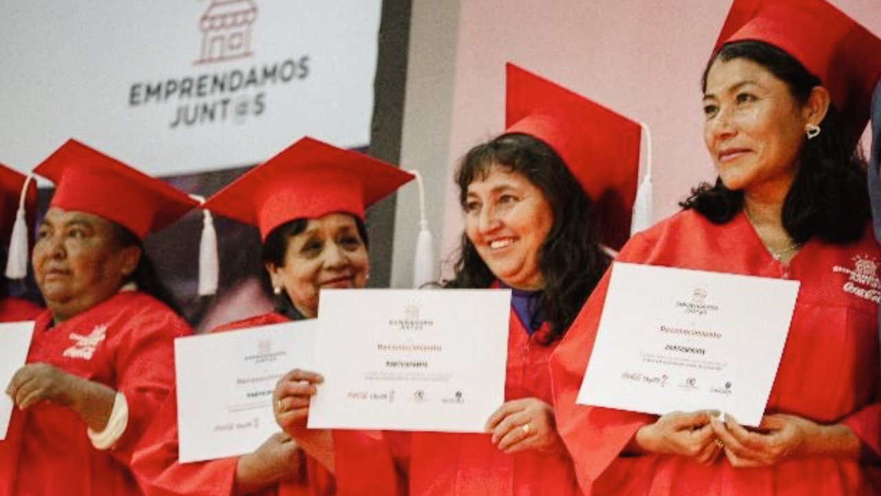Cuatro mujeres de rojo recién graduadas muestran sus diplomas