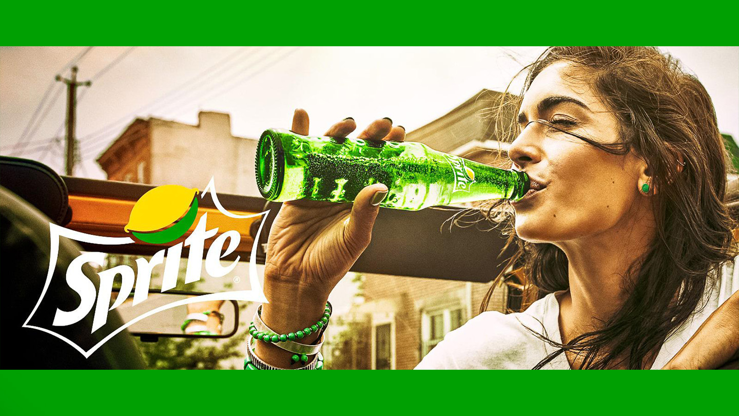 امرأة تشرب زجاجة سبرايت عليها شعار سبرايت على جانب الصورة