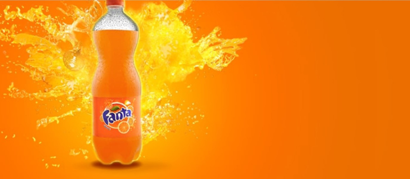 Fanta Orange bottle on a orange background with splashes of Fanta