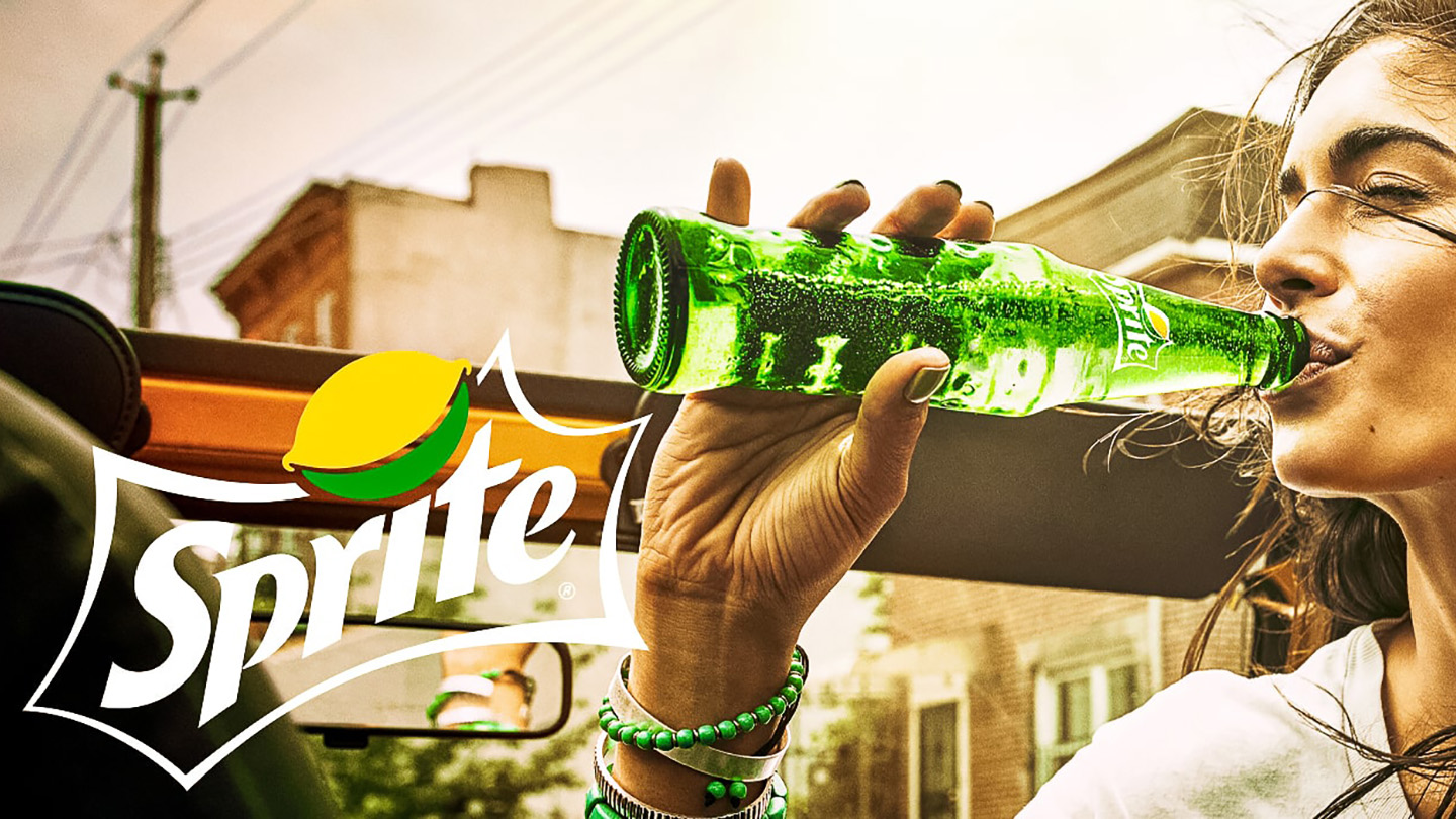 Woman drinking a bottle of Sprite with Sprite's logo on the side of the image