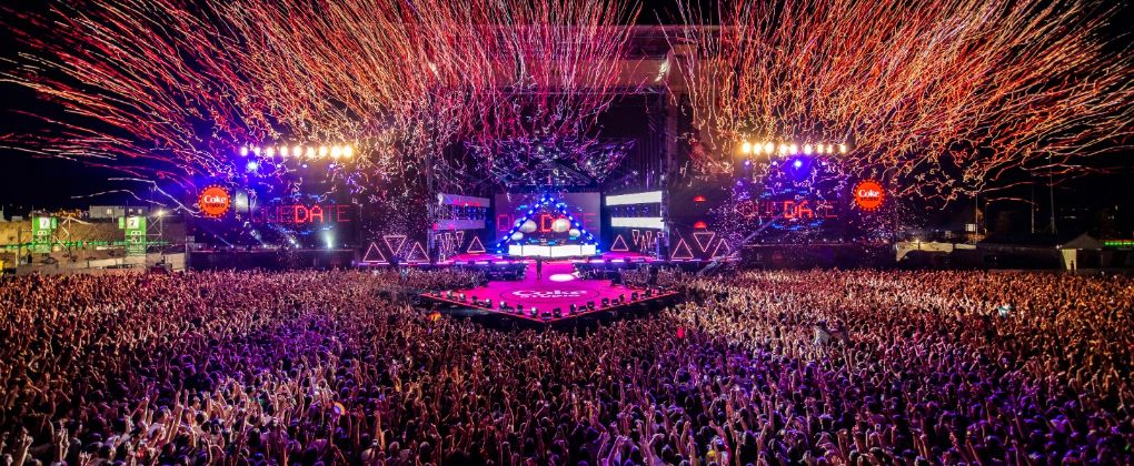 Escenario iluminado y decorado rodeado de público