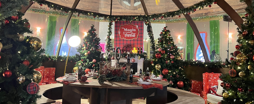 Una mesa de Navidad rodeada de regalos y árboles de Navidad