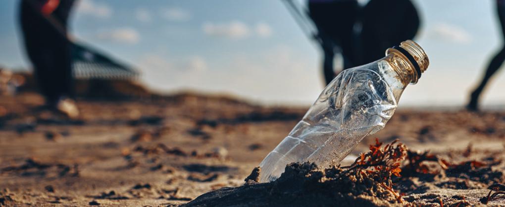 Botella semienterrada en la arena de una playa
