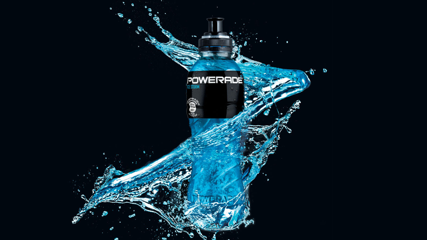 Botella Powerade con salpicaduras sobre fondo negro