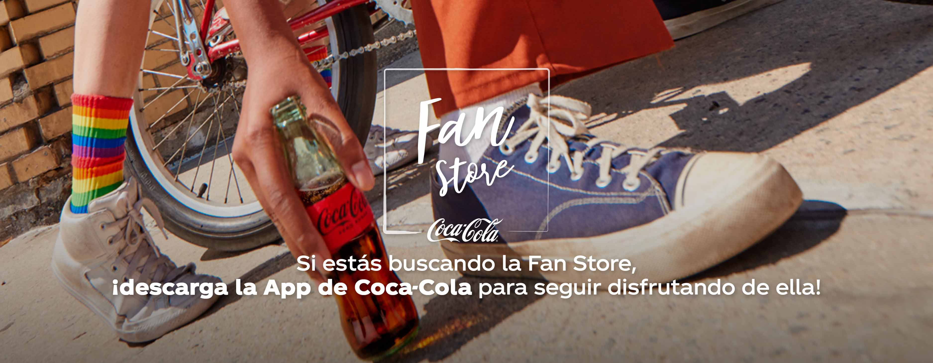 Persona sujetando botella de Coca-Cola en el suelo entre dos pies
