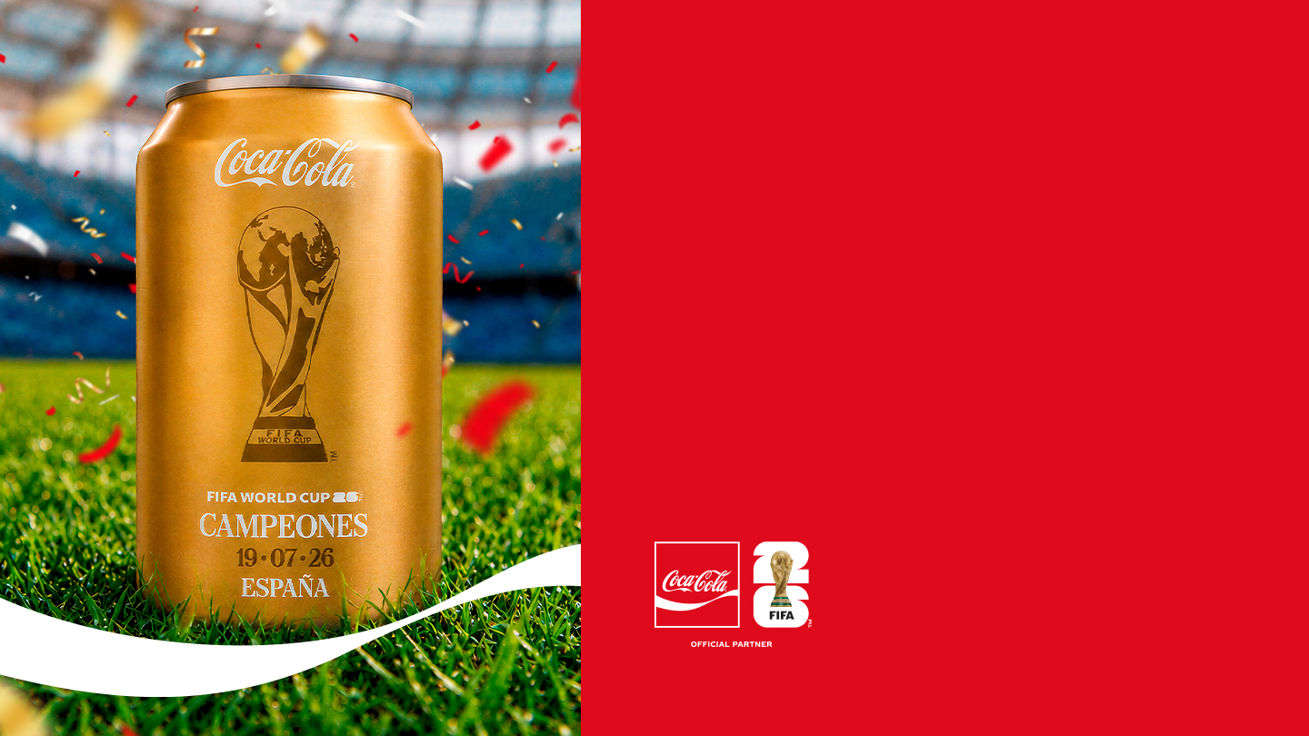 Lata dorada de Coca‑Cola conmemorativa de la selección femenina campeona del mundo, sobre un campo de fútbol con confeti rojo. A la derecha, fondo rojo con el logotipo de Coca‑Cola y el distintivo “1926”.