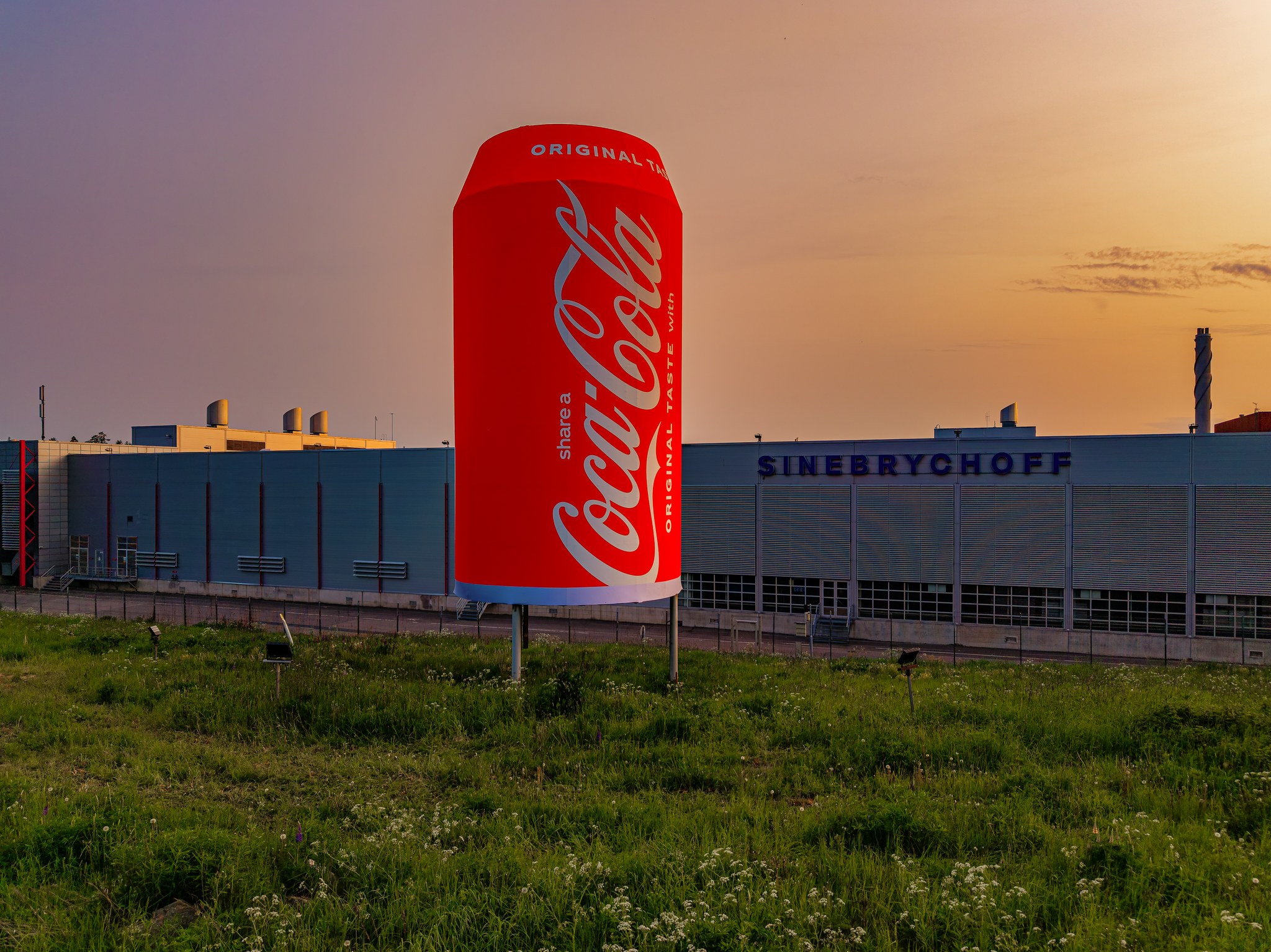 Auringonlasku ja jättiläismäinen Coca-Cola-tölkki Sinebrychoffin tuotantolaitoksen edessä. 