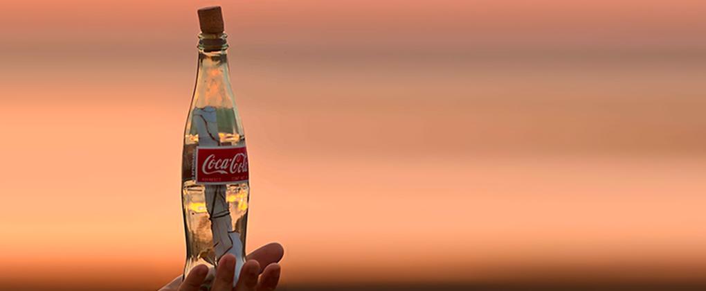 Nina Lesiga tient dans sa main la bouteille de Coca-Cola contenant le message original
