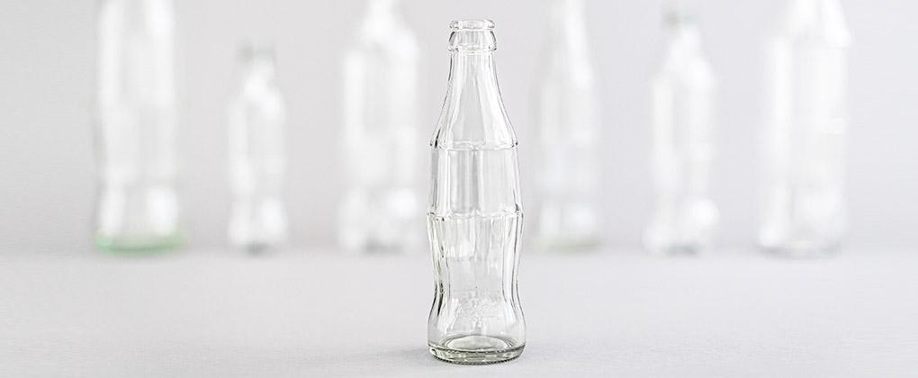 Des bouteilles de Coca-Cola recyclées vides sur fond blanc