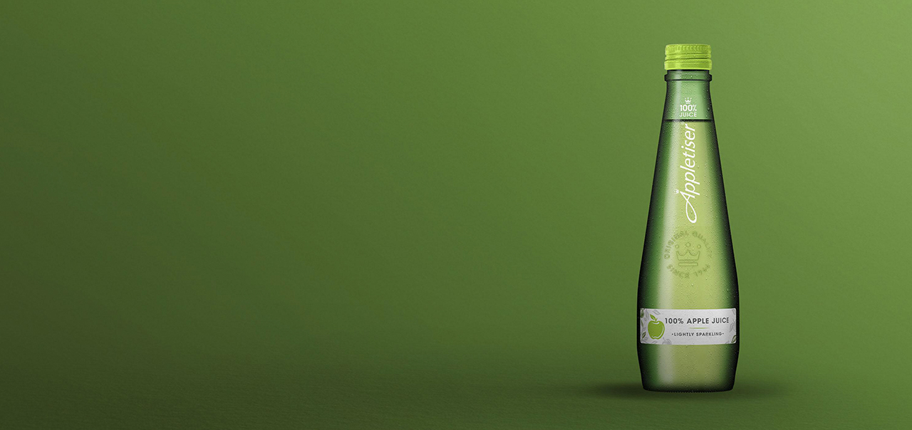 Appletiser bottle on green background.