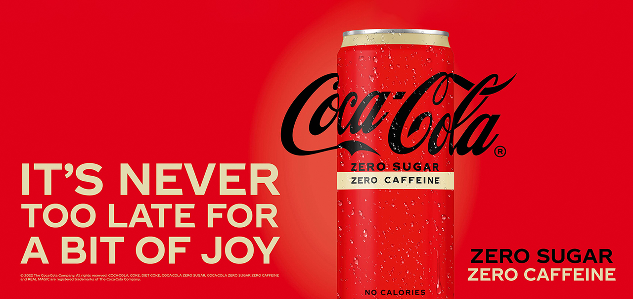 Banner with Coca-Cola Zero Sugar Zero Caffeine can and the phrase 'It's never too late for a bit of joy' written beside it.
