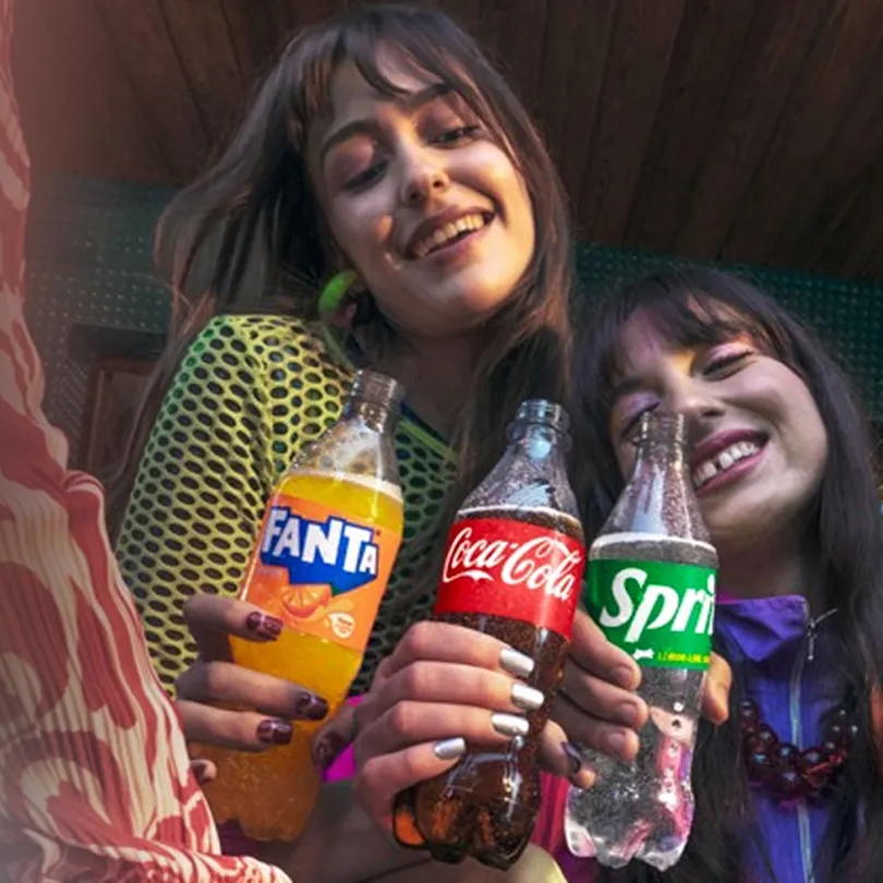 People holding bottles of Fanta, Coca-Cola, Sprite