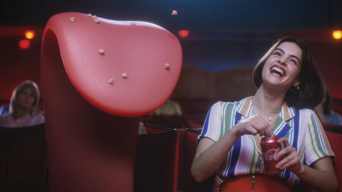 A girl and a tongue animation watching a movie in a movie theatre
