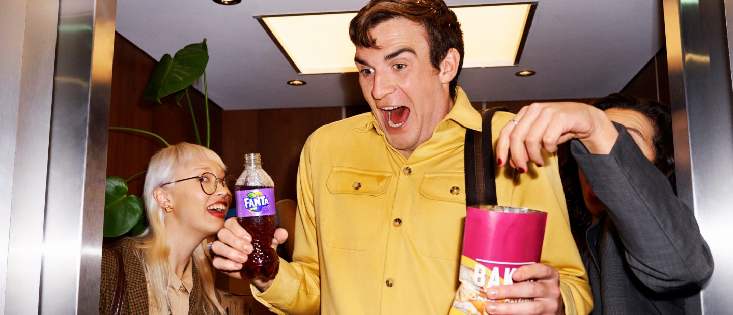 Man drinking fanta and eating snacks