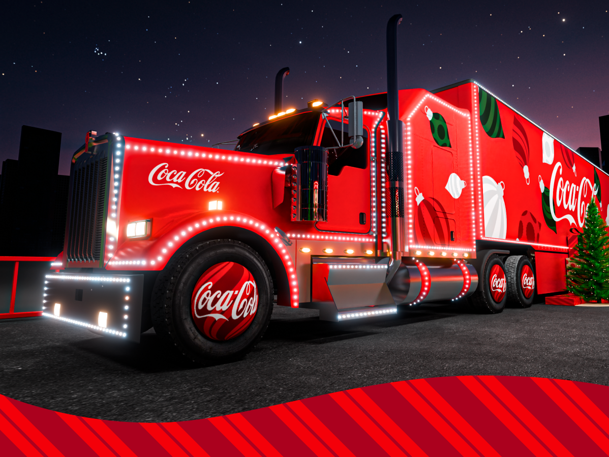 Camion rouge vif avec le logo Coca-Cola, décoré de lumières et d’illustrations de Noël, photographié de nuit sur une route