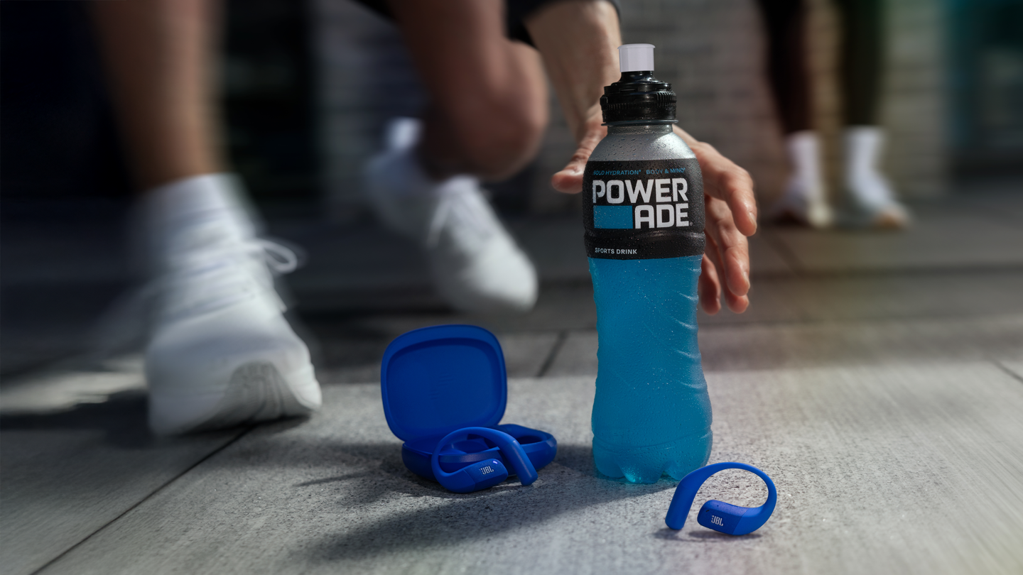 Eine Powerade-Flasche und ein paar blaue JBL-Ohrhörer.
