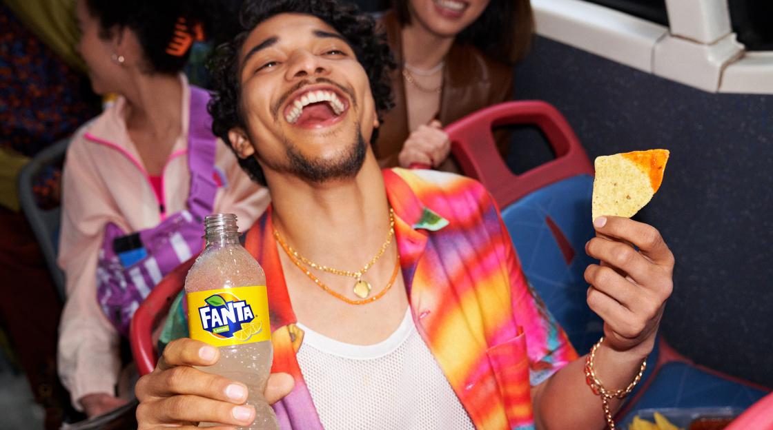 Man drinking fanta and eating nachos