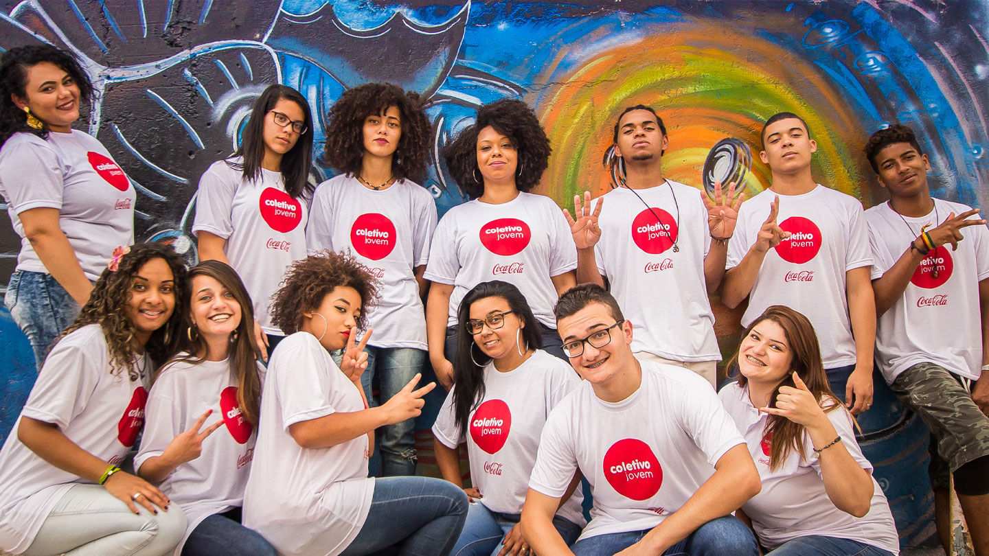 Grupo de jóvenes con playeras con el logotipo: Colectivo Jovem y el logotipo de Coca-Cola