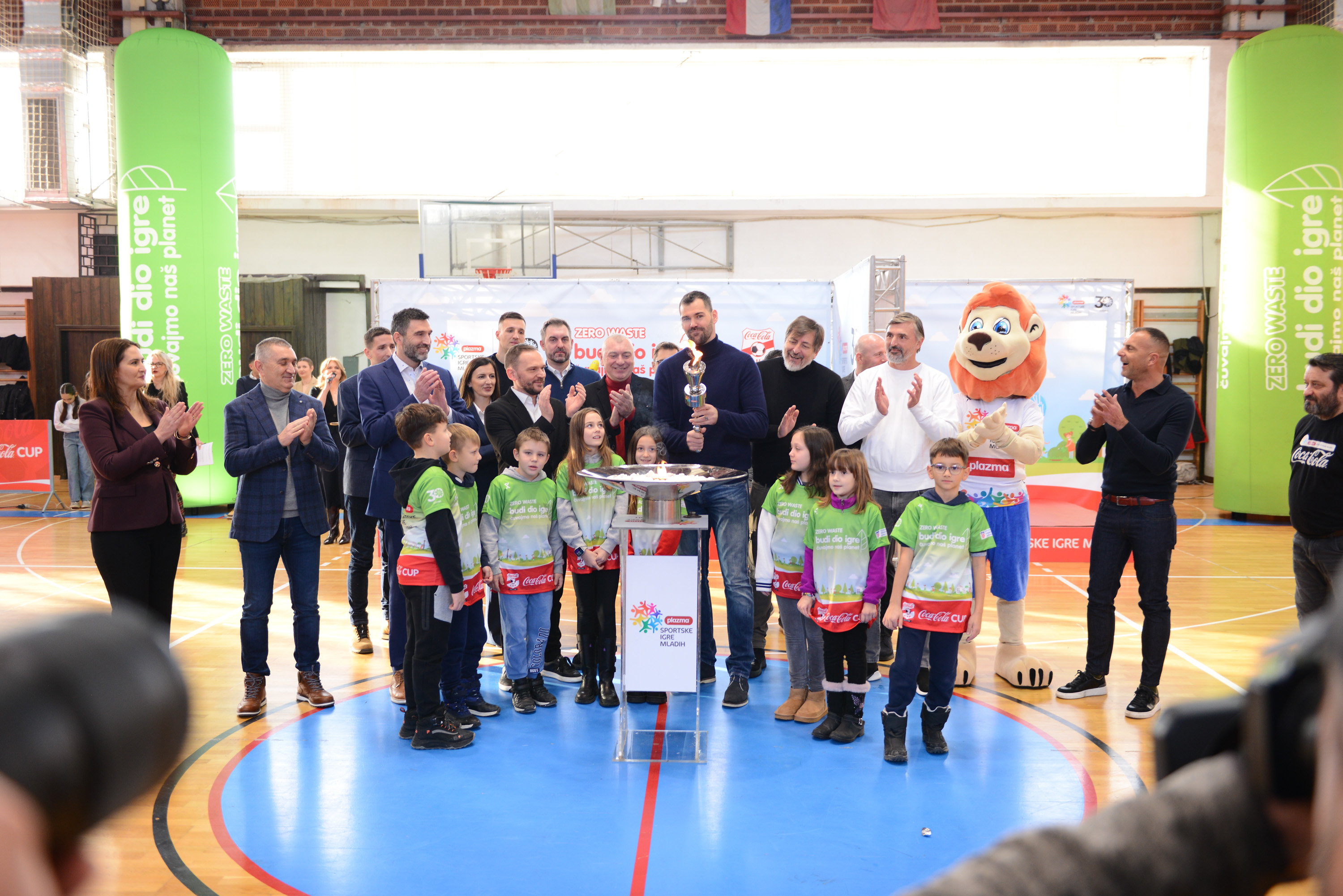 Djeca sudjeluju u nogometnom izazovu na označenom poligonu tijekom Coca‑Cola Cupa, uz podršku publike i sportsko‑edukativnu atmosferu u dvorani.