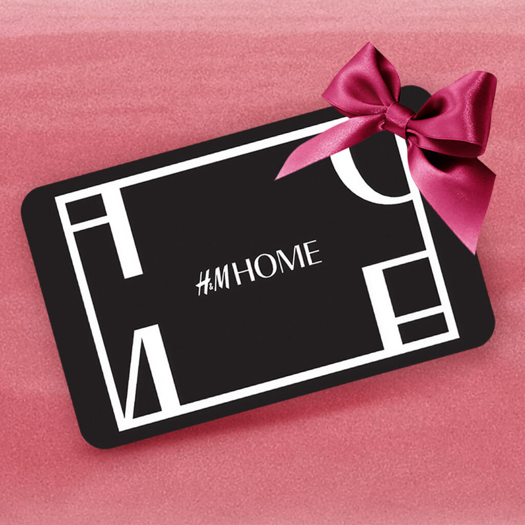 Fekete H&M Home utalvány rózsaszín háttér előtt.