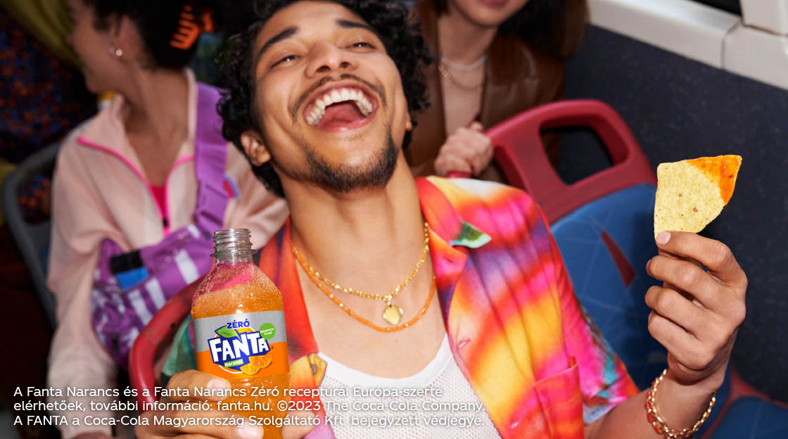 Man drinking fanta and eating nachos